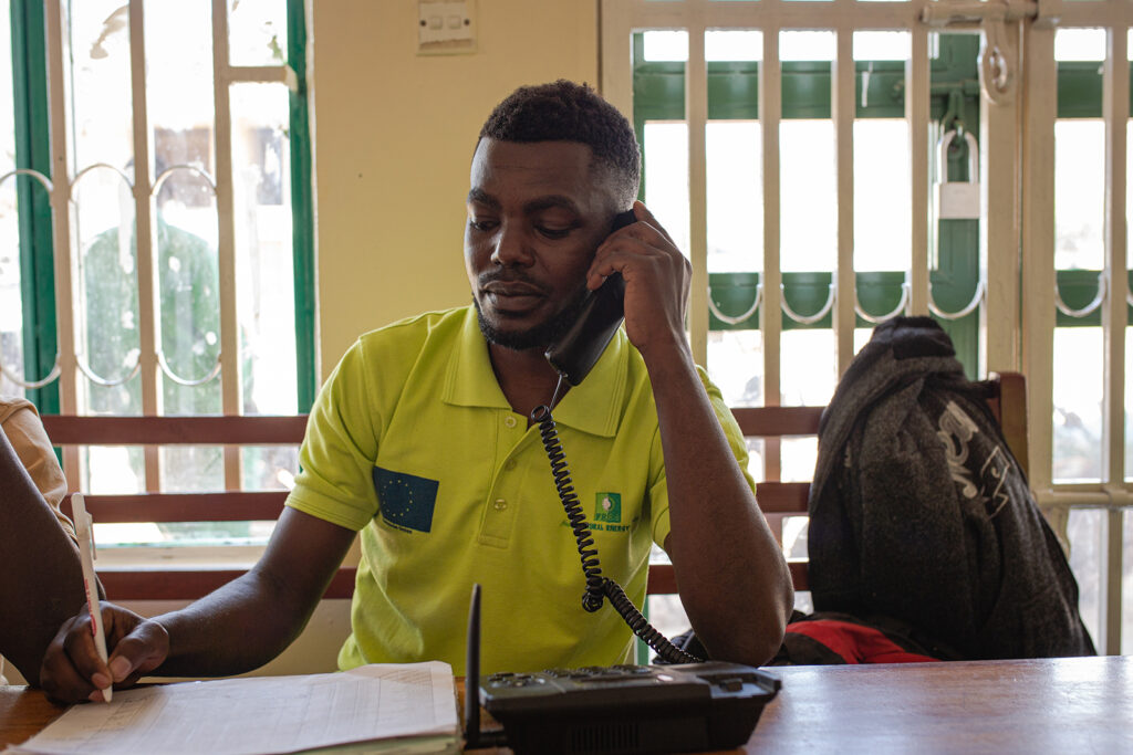 Nuwabine Onesmus, makes a debt collection call to one of the clients at Ntungamo Energy Store.